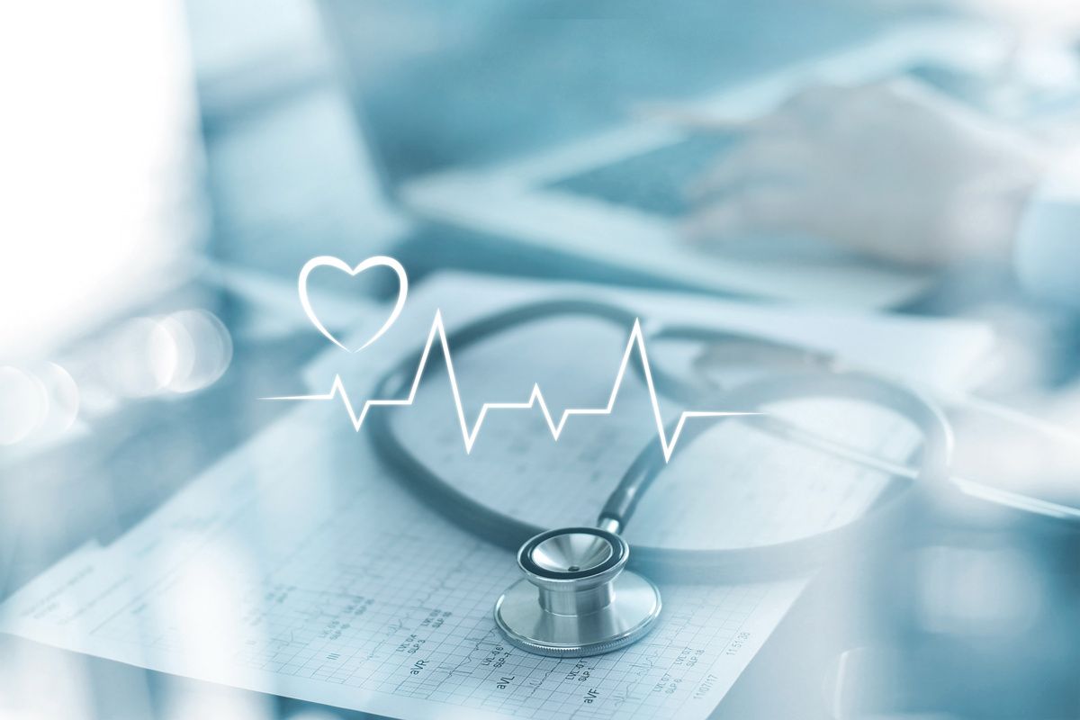 Stethoscope with heart beat report and doctor analyzing checkup on laptop in health medical laboratory background<br/>