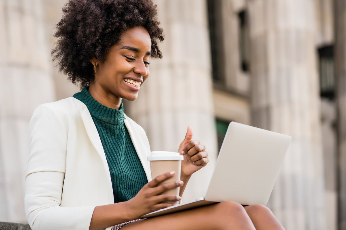 Business woman having a video call on laptop outdoors.